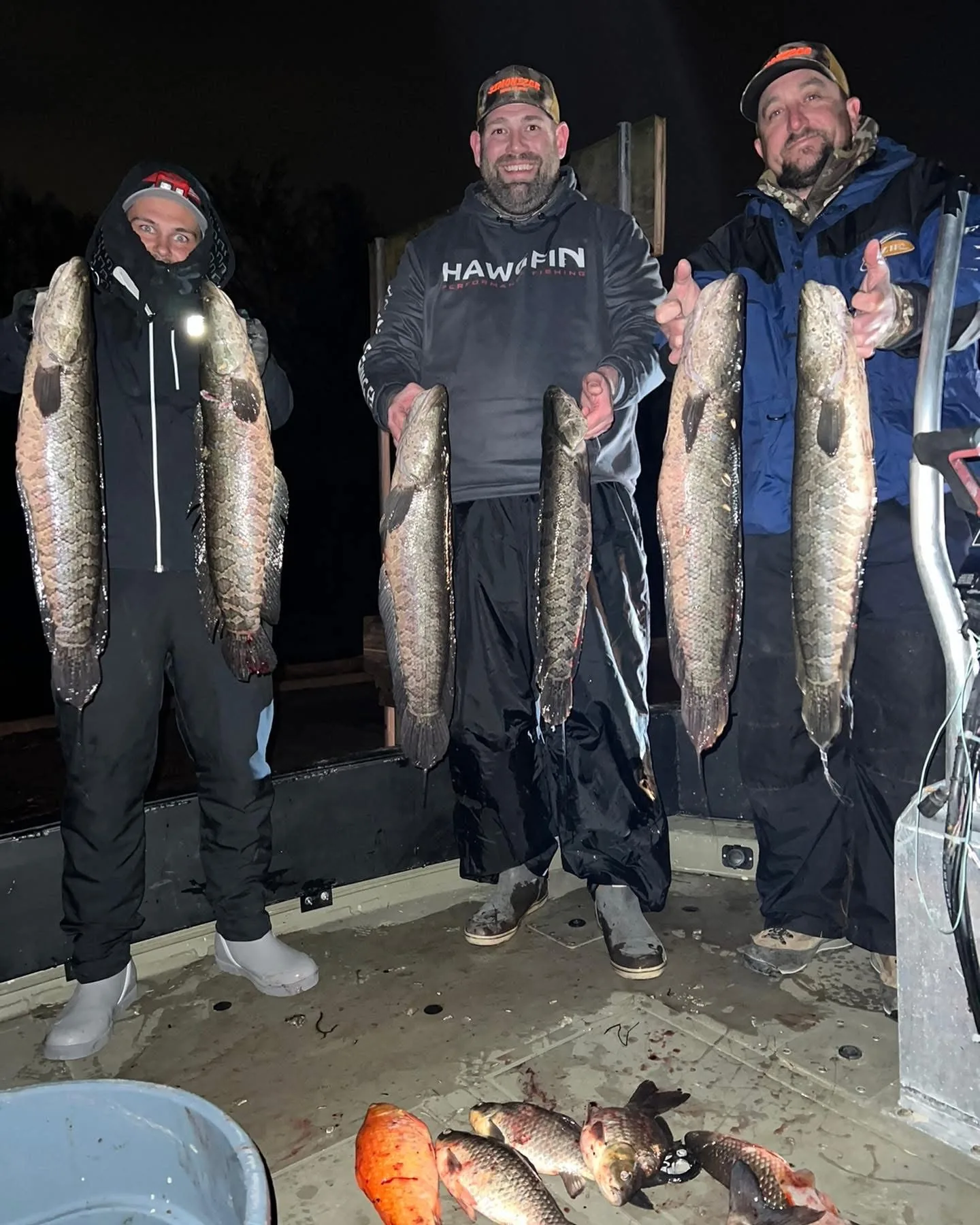 Group with snakeheads and nighttime bowfishing catch on deck