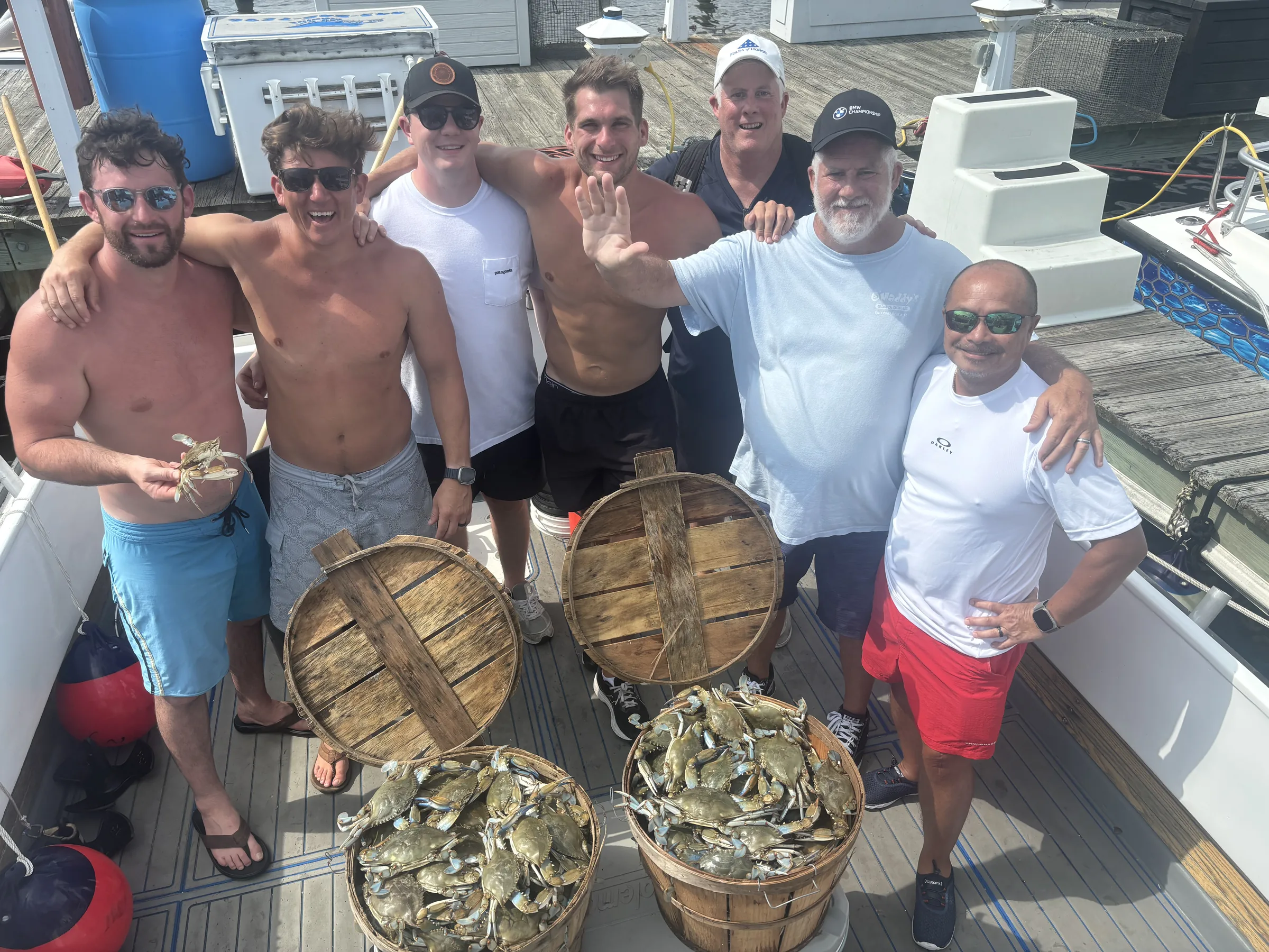 Group with bushel baskets of blue crabs after a Chesapeake Bay crabbing charter