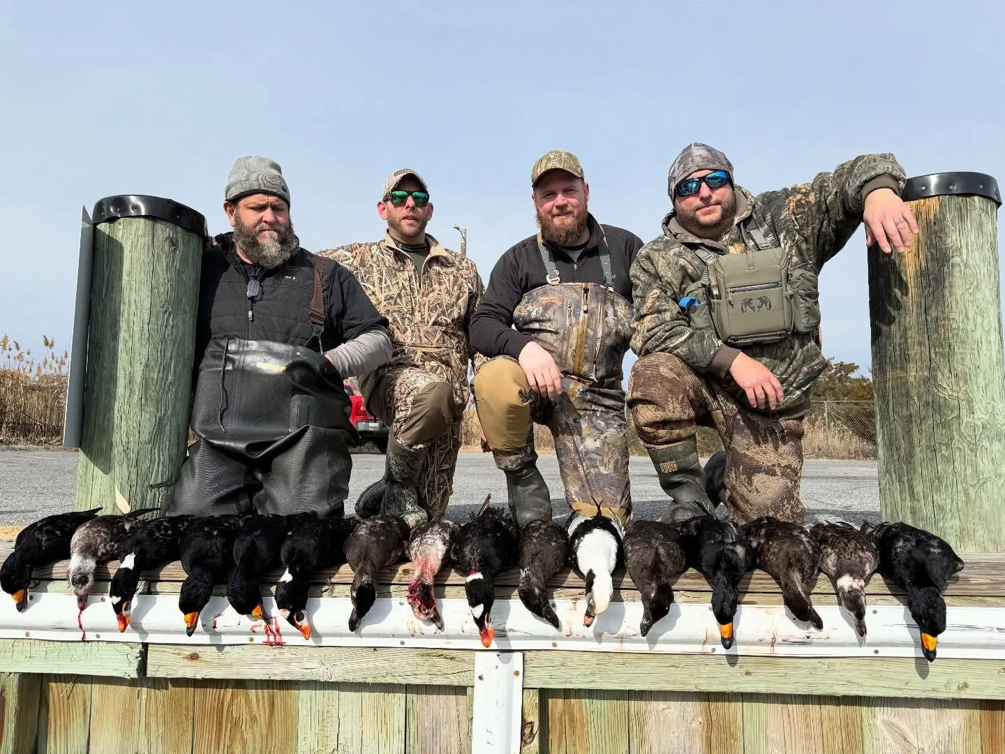 Guided duck hunting group with a sea duck spread on the dock