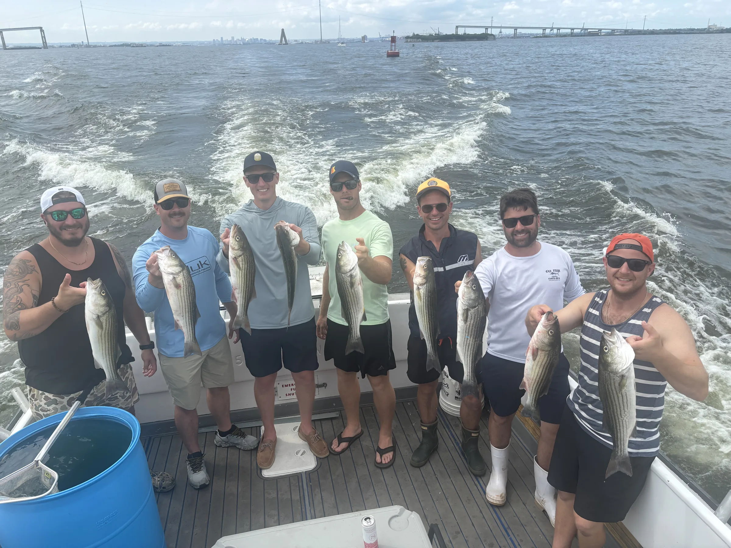 Adult group holding rockfish on a Chesapeake Bay corporate charter outing