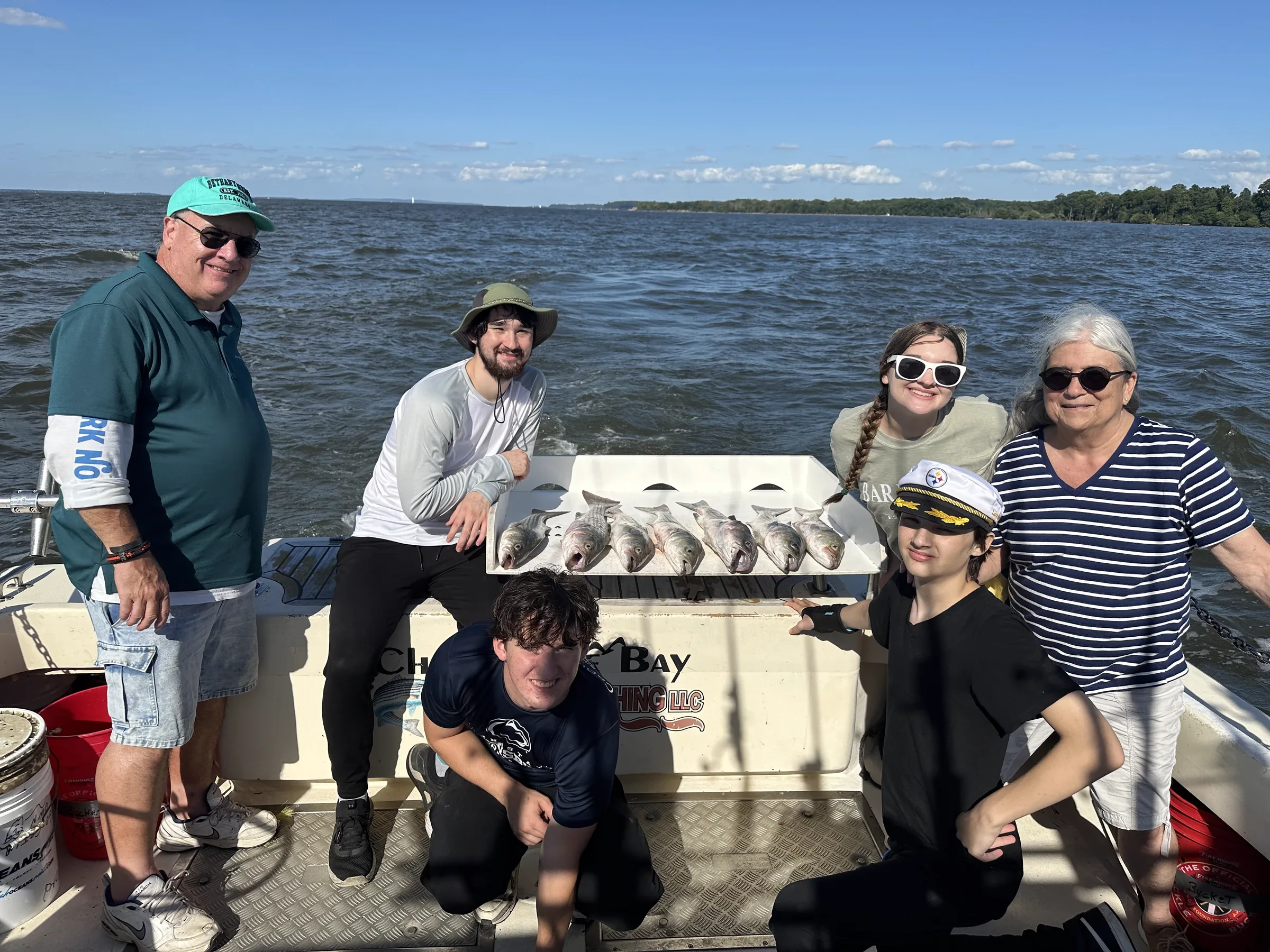 Family group with rockfish and a full cooler on a private Chesapeake Bay fishing charter